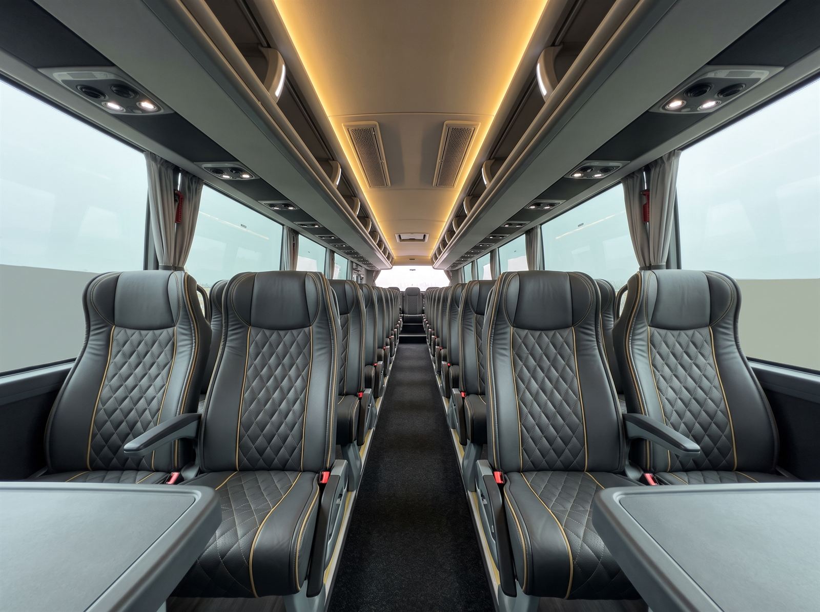 Intérieur d’un autocar VIP : sièges en cuir matelassé et surpiqûres dorées